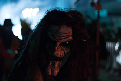 Close-up portrait of person wearing mask at night