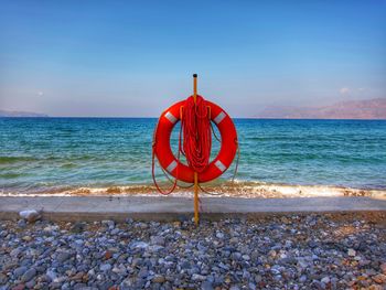 Red umbrella on beach against sky