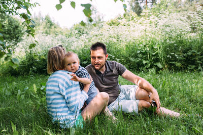 Mom, dad and little son spend time together in the summer outdoors