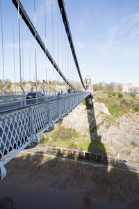 Bridge over river in city against sky