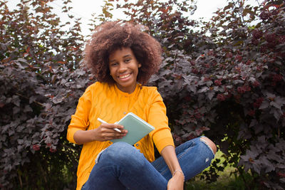 Portrait of smiling young woman sitting outdoors