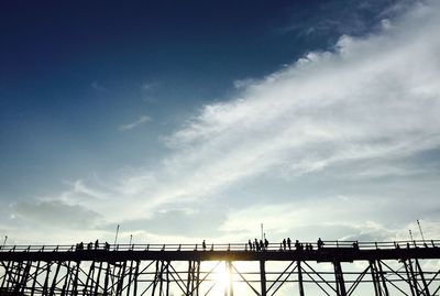 Low angle view of bridge against cloudy sky