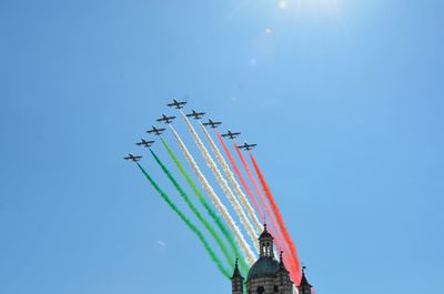 Low angle view of airplane flying against clear blue sky