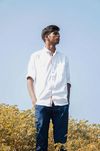 Full length of man standing on field against clear sky