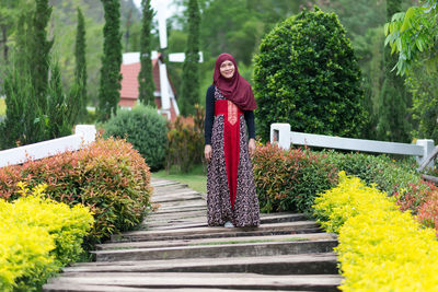 Portrait of woman standing by plants
