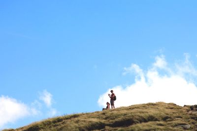 Low angle view of man standing on hill
