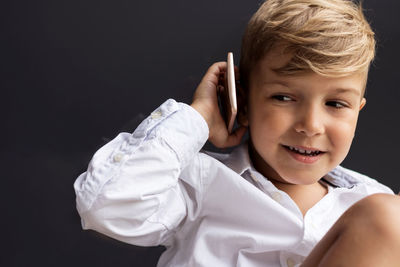 Cute kid using cell phone and communicating with someone.