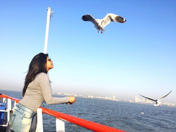 Woman on beach against clear sky