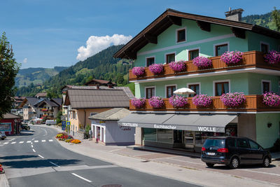 Houses by road in city against sky