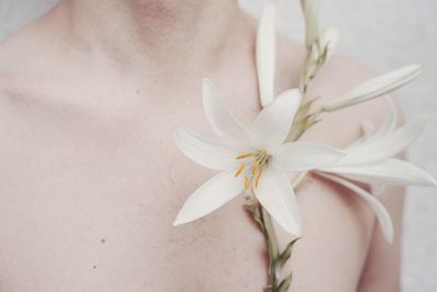 Midsection of shirtless man with flowers