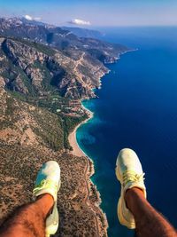 Low section of man flying in mid air during sunny day