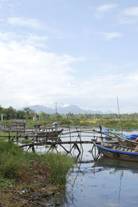 Boats moored at shore against sky