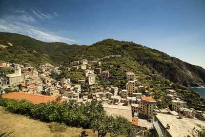 High angle view of town on hill against cloudy sky