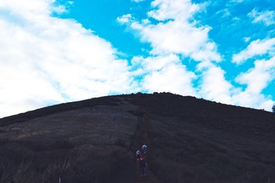 Silhouette of people against cloudy sky