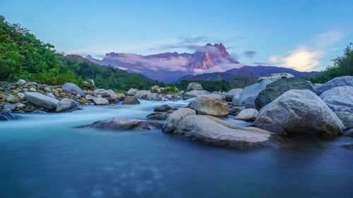 Scenic view of river and mountains against sky