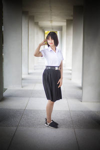 Smiling young woman standing in building