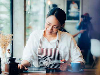 Young woman working on table at cafe