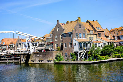 Graffiti on building by canal against sky