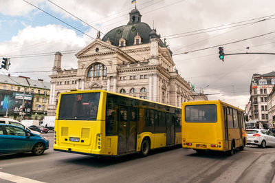 Cars on city street against sky
