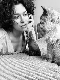 Portrait of young woman sitting on bed at home