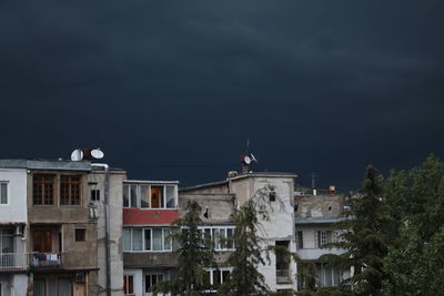 Buildings in city against cloudy sky