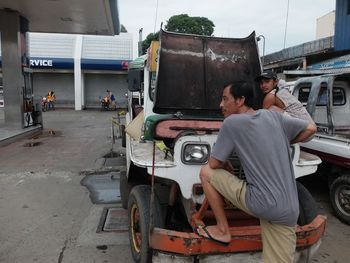 People working on motorcycle against sky