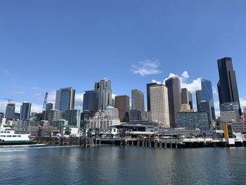 Modern buildings by bay against sky