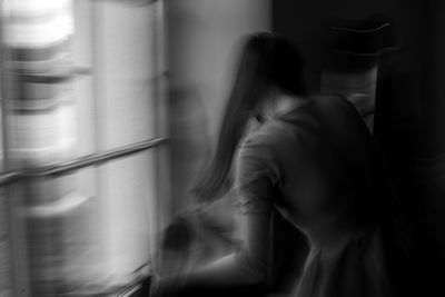 Blurred motion of woman at home
