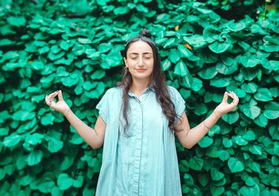 Portrait of woman standing against plants