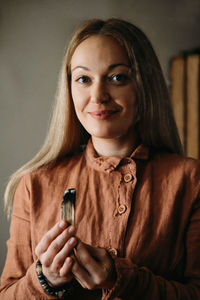 Woman meditating with palo santo in studio, cleaning space with smoke burning spiritual incenses 