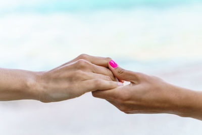 Horizontal view of unrecognizable women holding hands. love, couple and united concept.