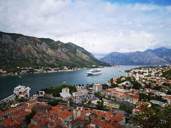 Aerial view of city by sea against sky