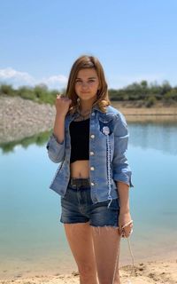 Portrait of teenage girl standing against sky