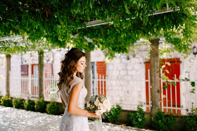 Side view of woman standing under plants