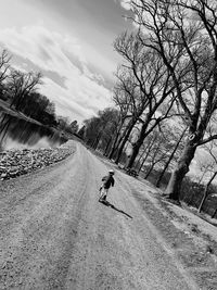 Rear view of man riding motorcycle on road