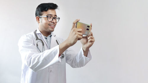 Smiling young man using mobile phone