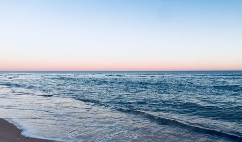 Scenic view of sea against clear sky during sunset