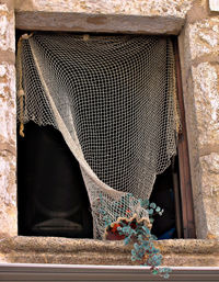 Low angle view of fishing net hanging on window