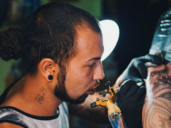 Man tattooing on hand