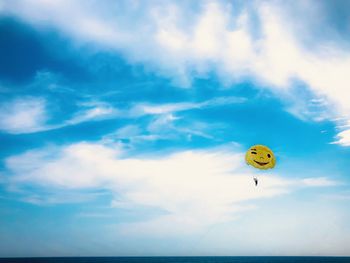 Low angle view of person paragliding against sky