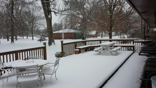 Empty bench on snow covered landscape