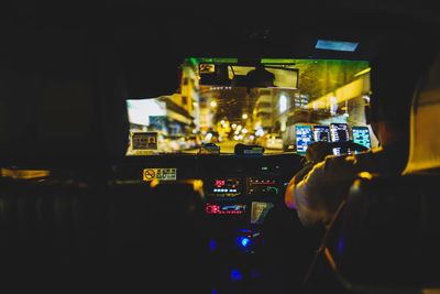 Rear view of man photographing illuminated car at night