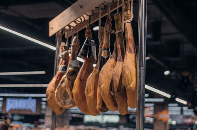 Jamon hangs on crossbar in supermarket. blurred background