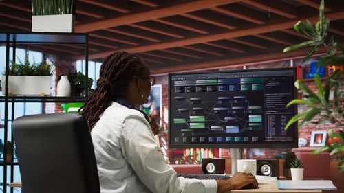Rear view of woman using laptop at airport