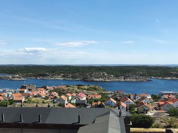 High angle view of townscape by sea against sky