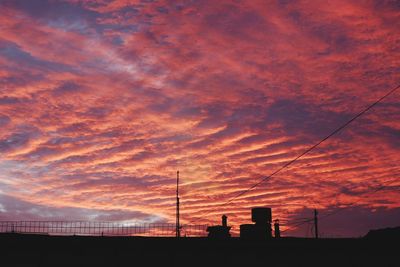 Low angle view of silhouette buildings against dramatic sky