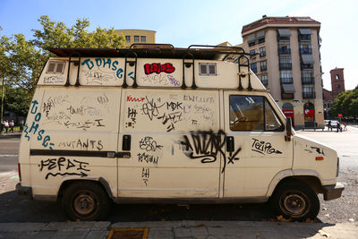 Graffiti on abandoned van parked on street