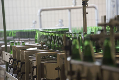 Bottling of mineral water in green bottles, in an industrial plant