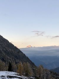 Scenic view of snowcapped mountains against sky during sunset