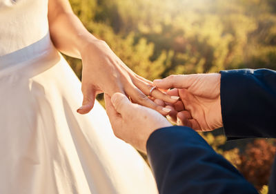 Midsection of couple holding hands